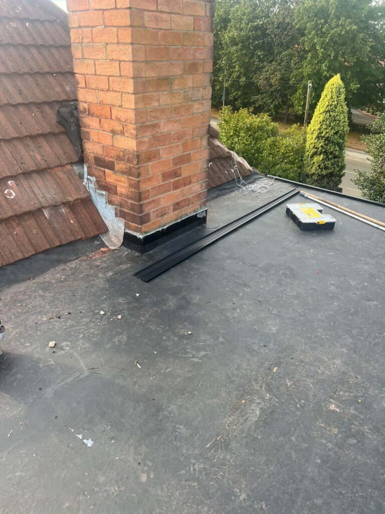 This is a photo of a flat roof which has just been repaired, there is also a chimney stack and some leadwork has also been dressed. Works carried out by Burwell Roofing Repairs